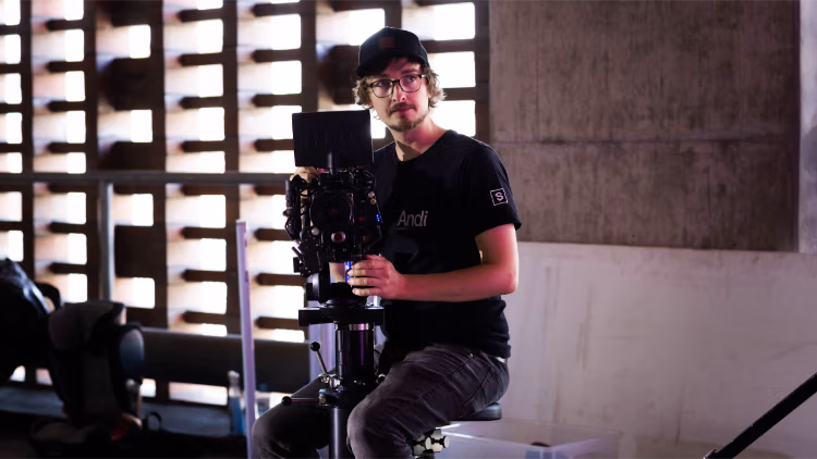 Kameramann mit professionellem Filmrig in modernem Industrieumfeld – Behind-the-Scenes Aufnahmesituation von Spreadfilms