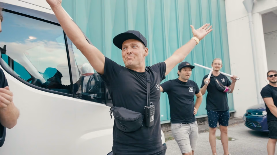 Behind-the-Scenes von Spreadfilms: Teammitglied hebt jubelnd die Arme, während das Produktionsteam zusammensteht