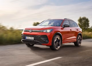 Roter VW-SUV fährt auf einer Landstraße - ein Foto von Spreadfilms