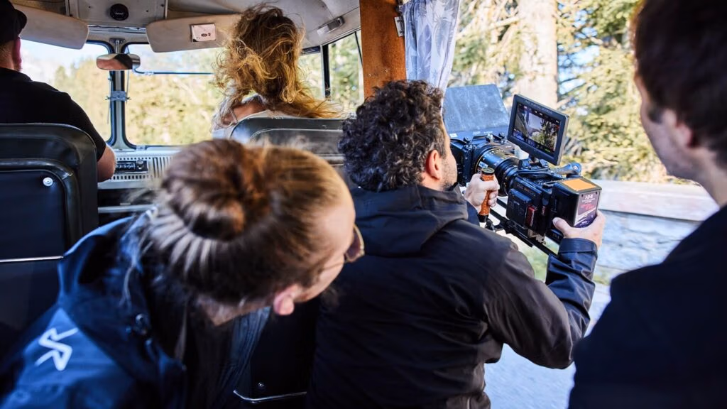 Filmcrew im fahrenden Bus – Kameramann filmt Szene durch die Seitentür - für Imagefilm von Spreadfilms