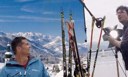 Bild von einem zwei Männern die for einem Gebirge stehen, mit mehreren Skiern - eine Szene aus einem Tourismusfilm von Spreadfilms
