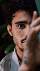 Nahaufnahme eines Mannes, der teils verdeckt in die Kamera blickt - von Spreadfilms