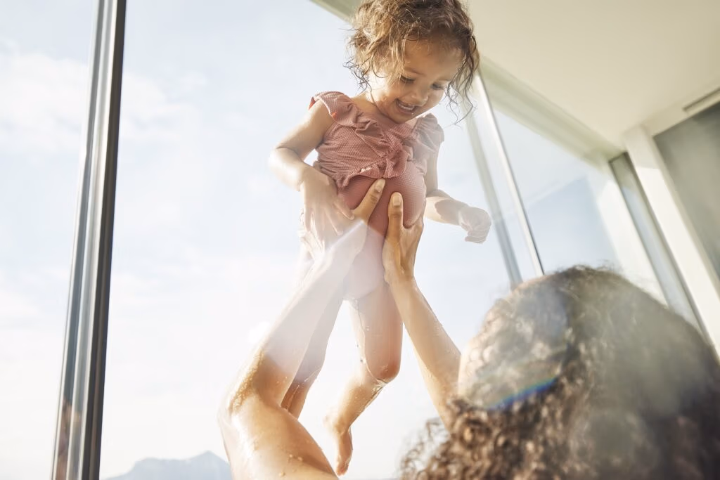 Foto von Lachendem Kind das hochgehoben wird, heller und fröhlicher Familienmoment - von Spreadfilms