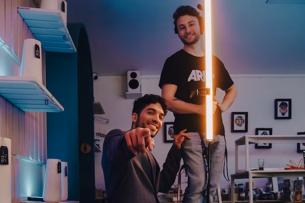 Zwei Crewmitglieder am Filmset von Spreadfilms , einer zeigt in die Kamera, der andere hält eine Stablampe.