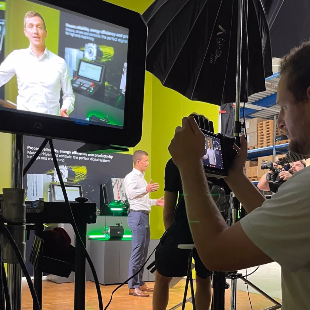 Kamerateam filmt einen Mann vor einem industriellen Technik-Setup - Behind-the-Scenes einer Spreadfilms Produktion